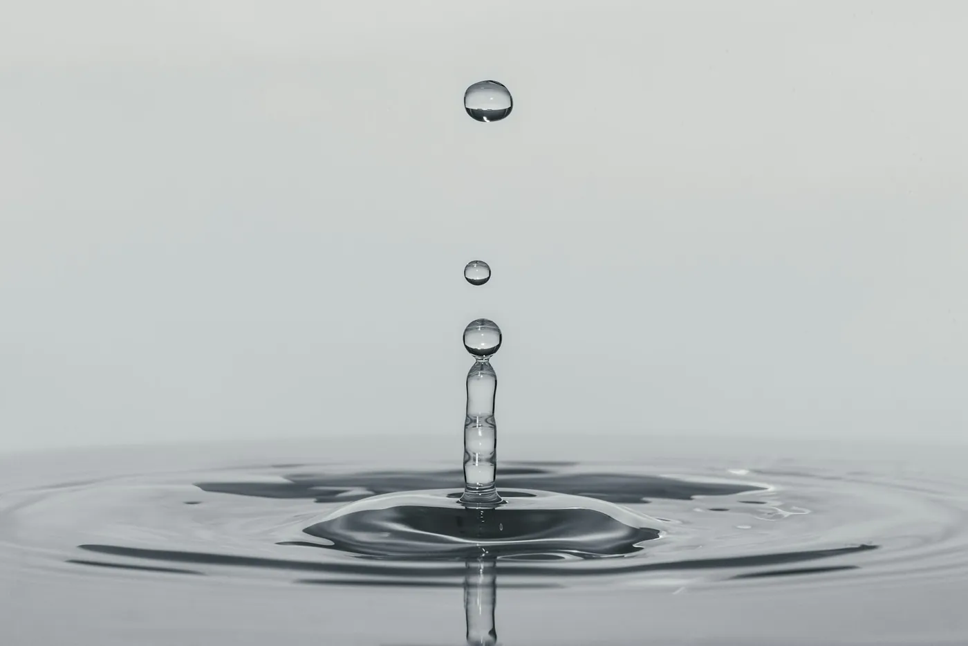 A single drop of water falling onto a still surface